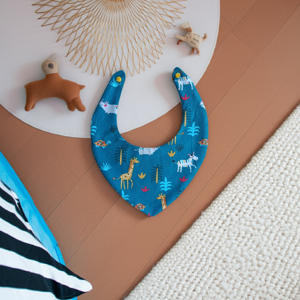bavoir bandana bébé mis en scène avec des jouets d'enfant