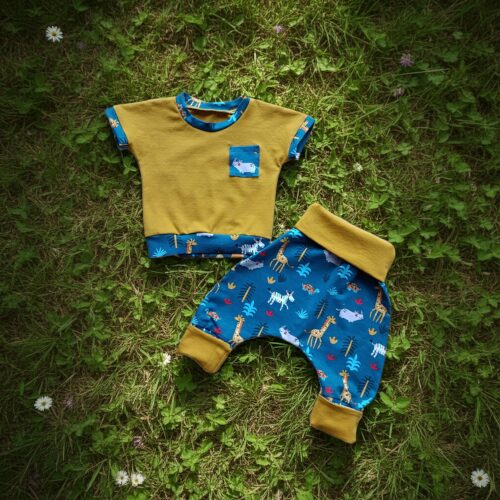 Ensemble évolutif bébé motifs animaux posé dans l'herbe