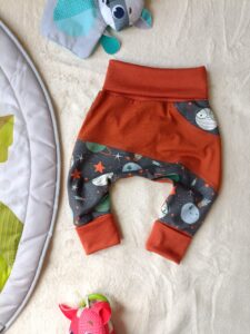 sarouel bébé évolutif - Planètes - chevilles et ceintures repliées - posé à plat sur une couverture