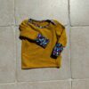 photo du tee-shirt évolutif bébé couleur moutarde et bordures colorées