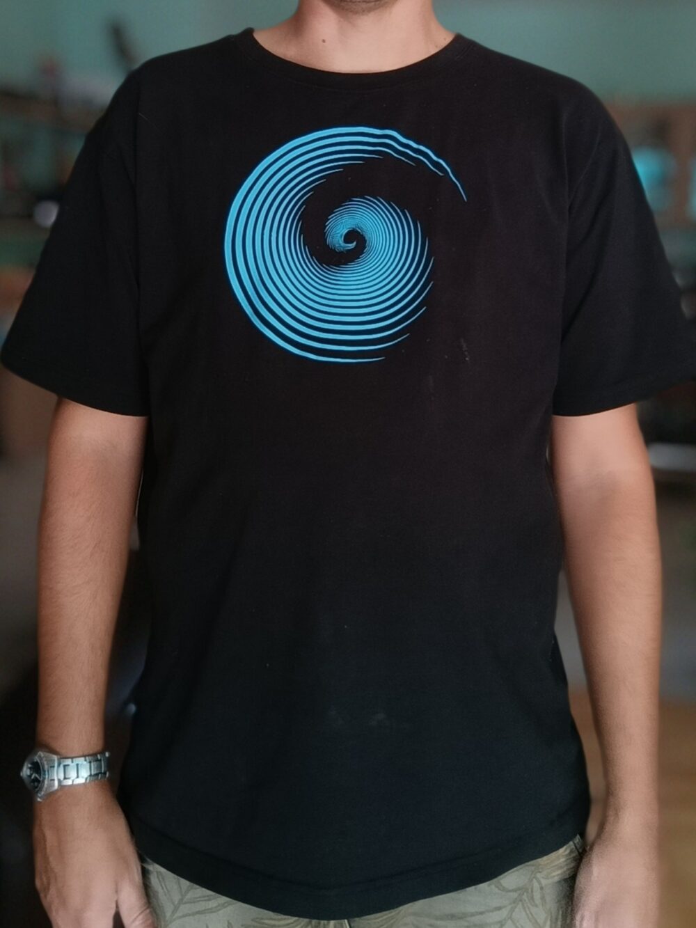 photo du tee-shirt homme noir avec un modèle turquoise spirale