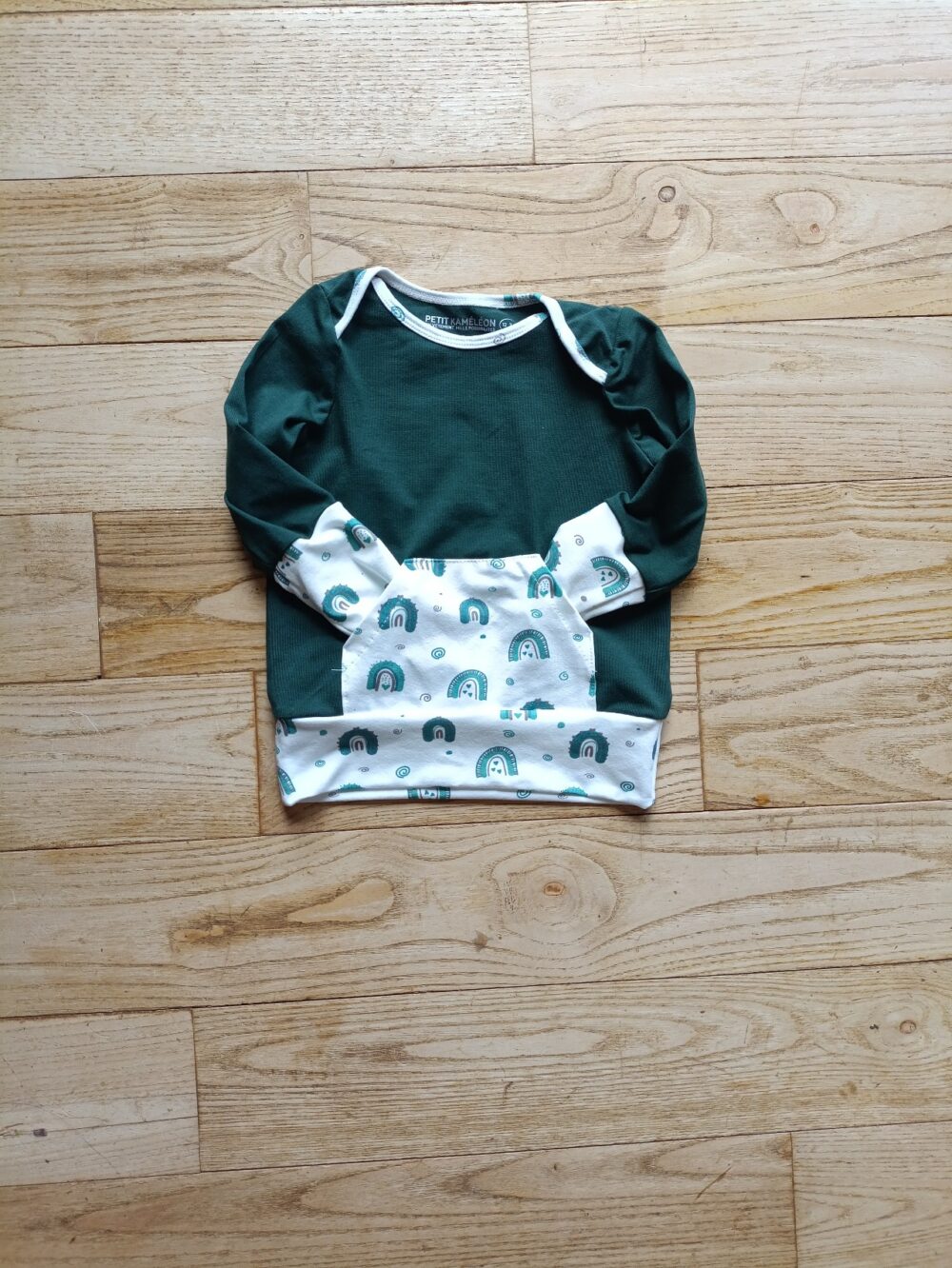 photo du sweat évolutif bébé vert sapin et poche kangourou blanche motif arc en ciel, associée aux poignets et à la bande de bas
