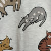 Light gray fabric printed with a repeating pattern of cute, colorful cartoon cats in various poses.