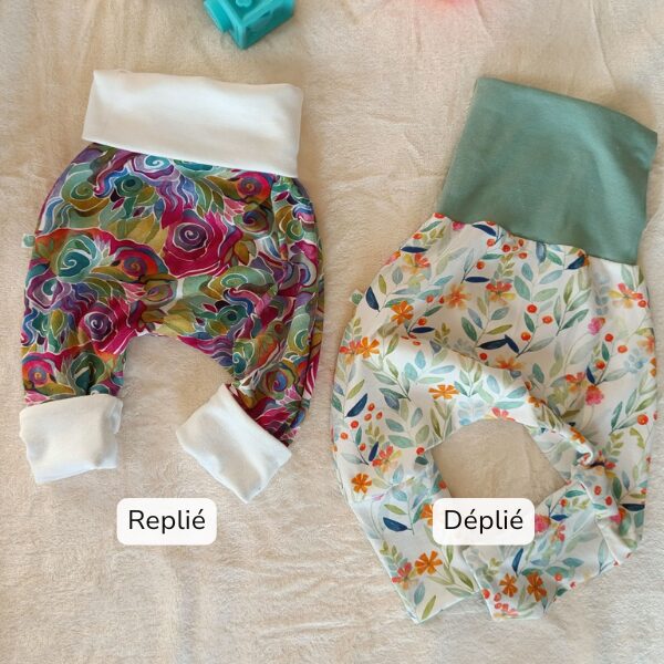 Deux sarouels évolutifs pour bébé illustrant l’évolution de la taille : à gauche, ceinture et revers repliés pour le début de taille ; à droite, ceinture et revers dépliés pour la fin de taille.